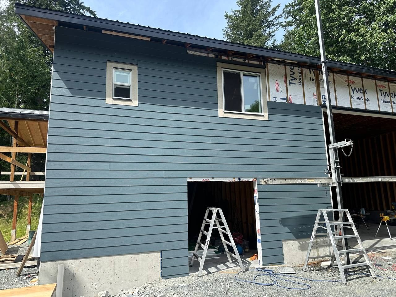 Blue lap siding going on over house wrap