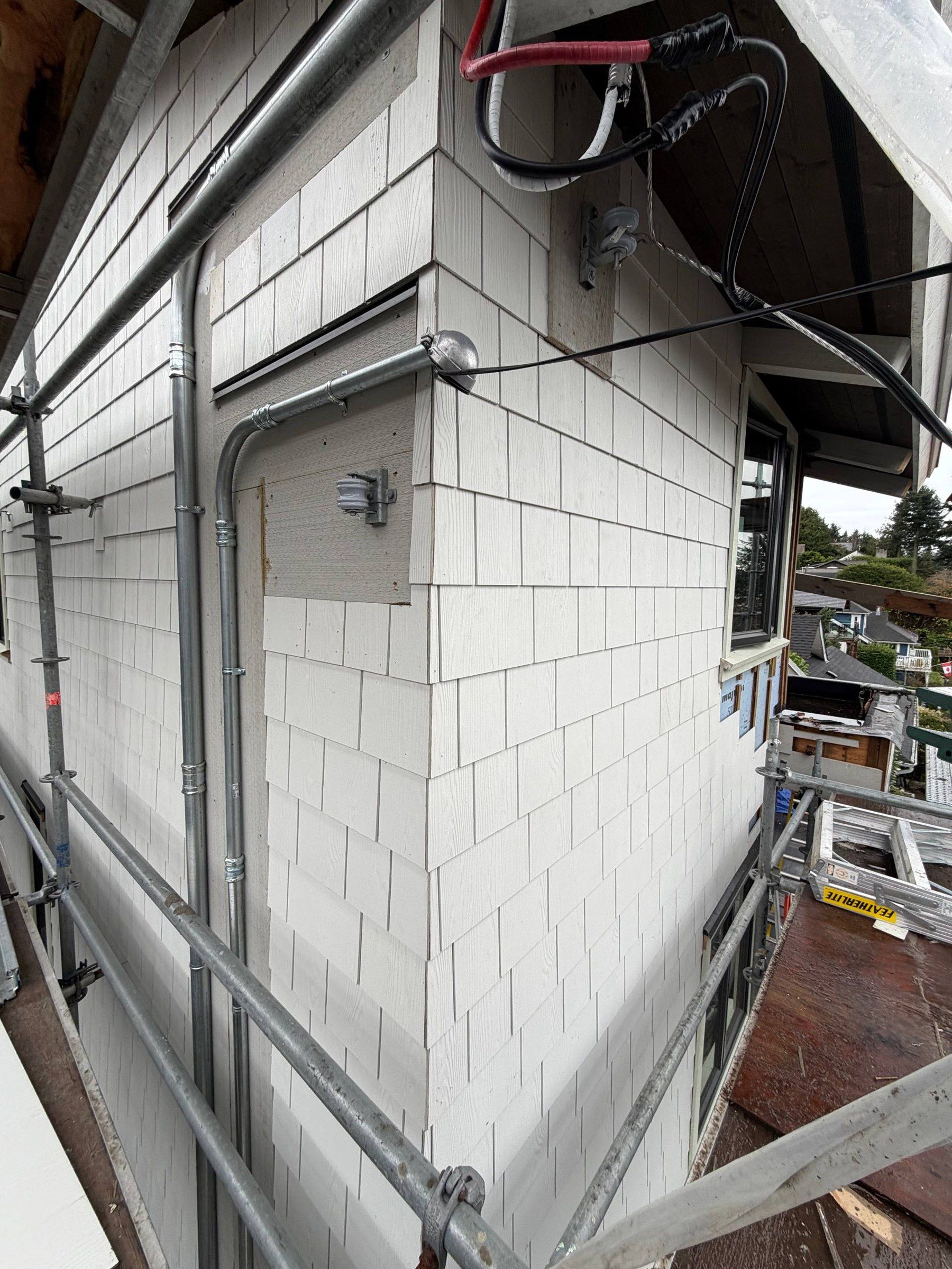 Scaffolding against a shingle wall corner during a Nordic Bears re-side