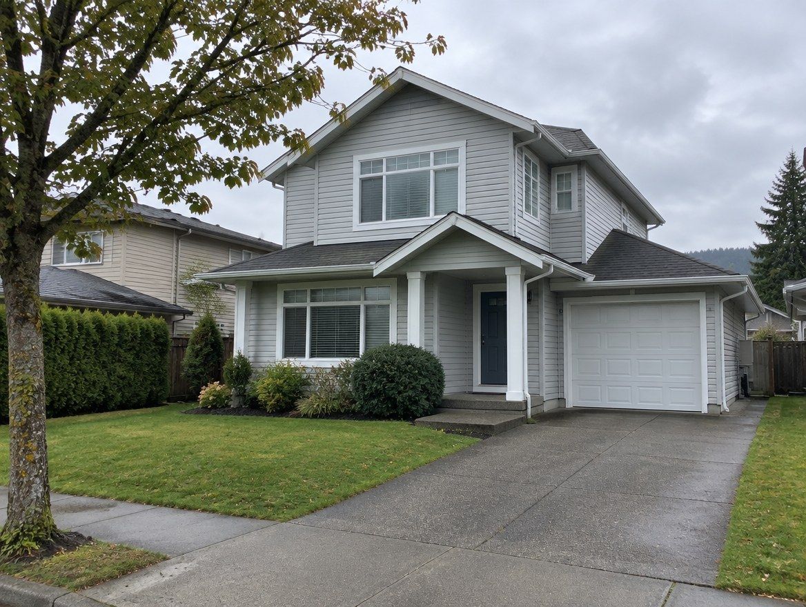 A two-storey house in pale grey vinyl lap siding, seen from the sidewalk